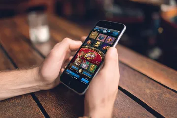 A cheerful woman in traditional clothing using her smartphone during a festive moment, showing how easily the 4777BED app fits into everyday life.