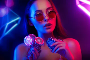 A woman smiling by bright slot machines showing lucky symbols, showcasing the exciting slot offerings at 4777BED.